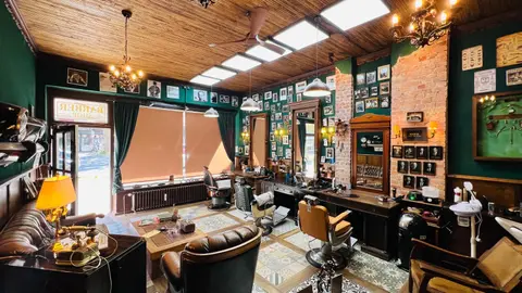 Das Schaufenster mit dem Schriftzug Barber Shop und die Wall of Fame am Ziegelpfeiler