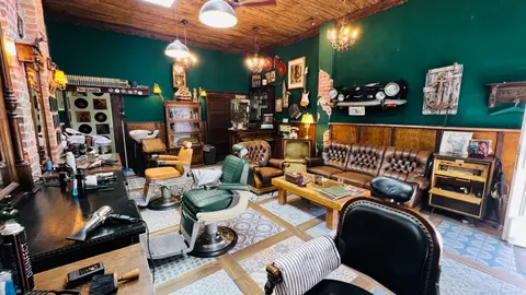 Die Lounge mit Chesterfield-Sofa, Röhrenfernseher und Schallplatten an der Wand